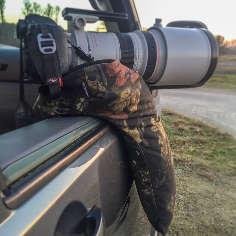 pixelpenguin- Een gecamoufleerde camera vastgebonden aan de zijkant van een auto, vermomd als een tweepotige zitzak.