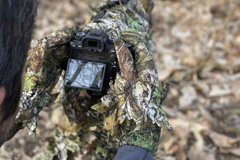 Handen in 3D camouflage handschoenen bedienen camera